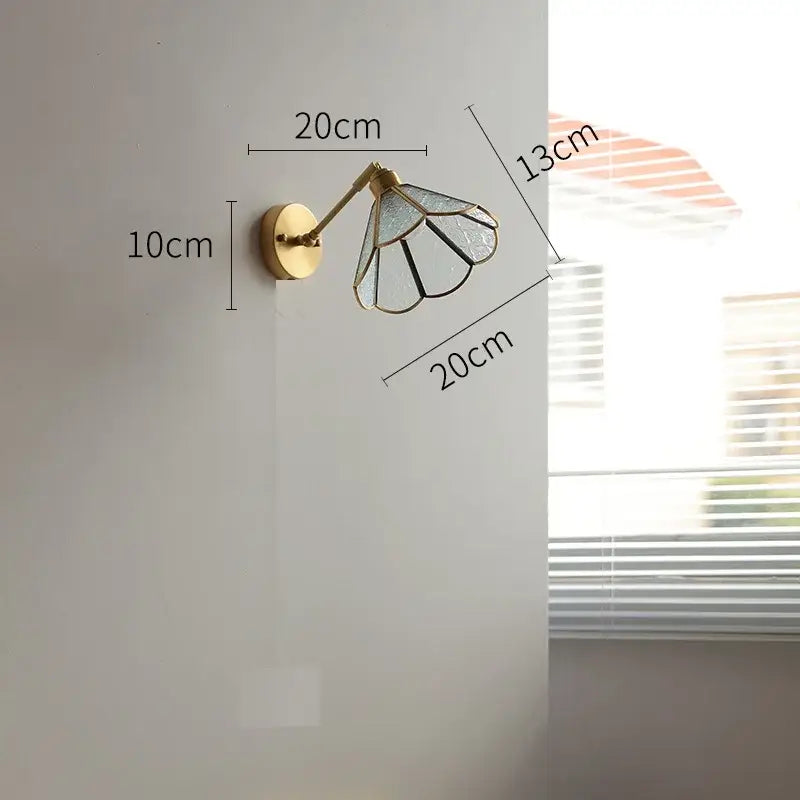 Vintage brass wall lights with a gold-toned stained glass led shade featuring black and clear panels for bedroom use