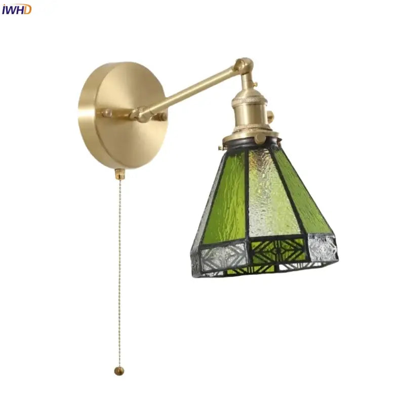 Vintage brass wall sconce with ornate green glass led shade and geometric black leaded patterns for bedroom lighting
