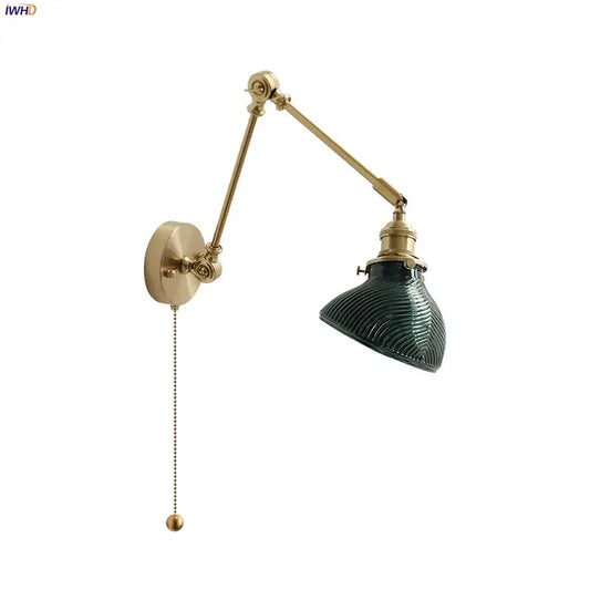 Vintage brass wall light fixture with dark green ribbed glass shade and adjustable arm for bedroom use