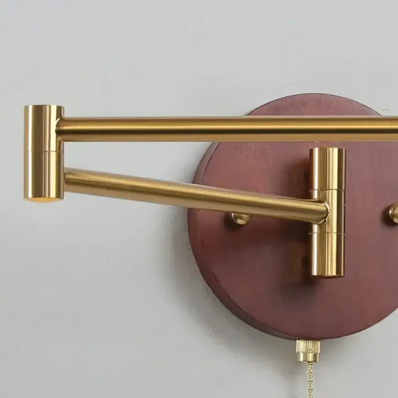 Gold-toned articulated wall lamp with maroon wooden backplate and brass hardware from decorbites creamy iron led collection