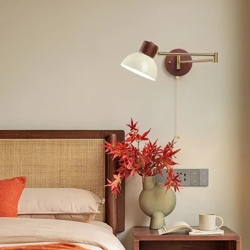 A modern wall lamp with brass arm, dark brown base and creamy iron led off-white conical shade by decorbites creamy iron