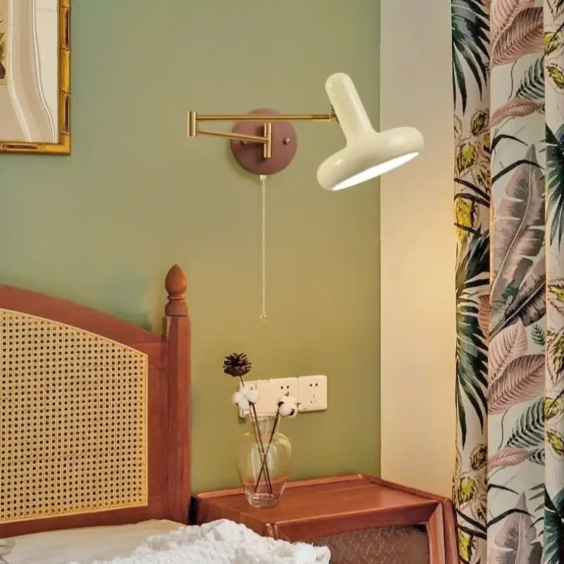 A sleek white wall lamp with brass arm and adjustable head featuring decorbites creamy iron led for bedroom use