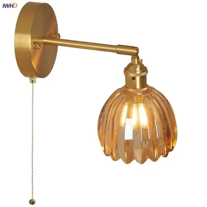 Brass-finished wall light with decorbites amber glass vintage ribbed shade and attached pull chain for bedroom use