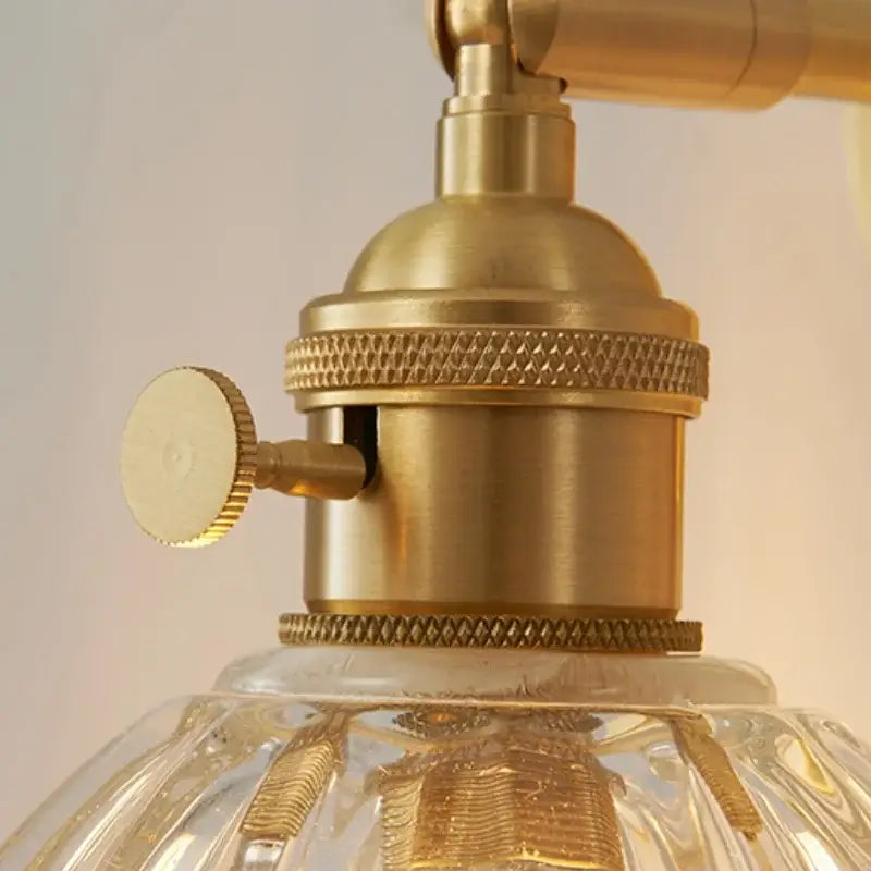 Vintage brass wall light with ribbed amber glass and brass-finished socket featuring textured ridged bands and knob