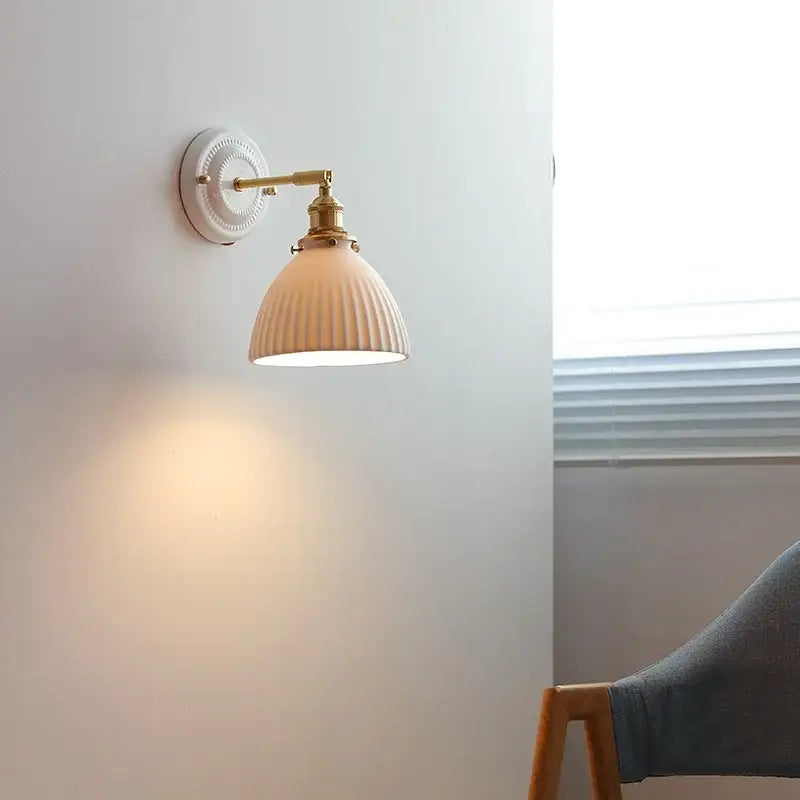 Vintage brass led wall light with cream ribbed ceramic shade and metal arms for bedroom sconce lighting