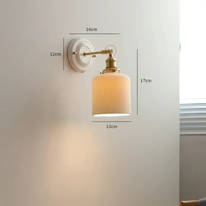 Vintage brass led wall light with ribbed off-white glass shade designed as a bedroom sconce fixture