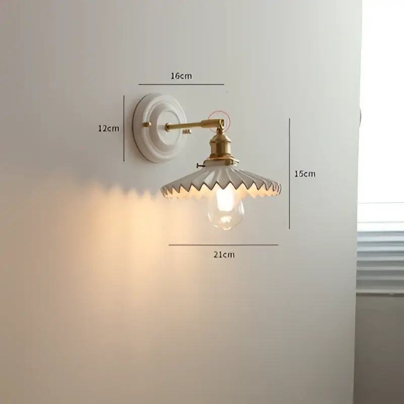 Vintage brass and ribbed glass led wall light with white ceramic base and scalloped clear glass shade for bedroom sconce