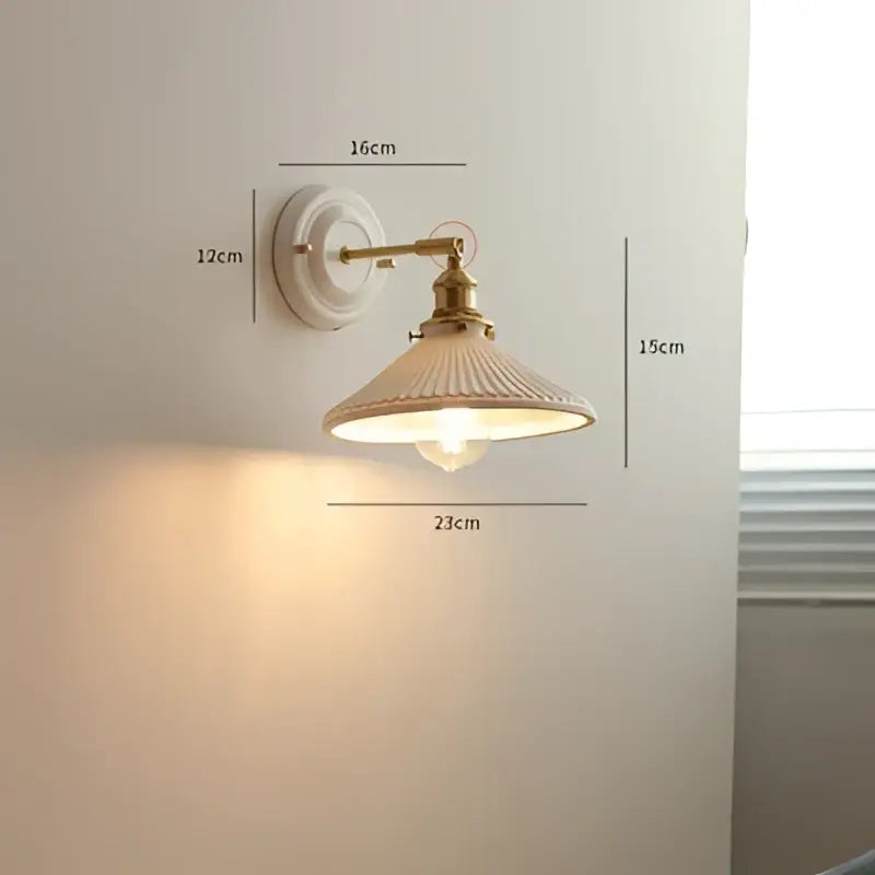 Vintage brass and ribbed glass led wall light featuring cream ribbed glass shade and brass metal arms for bedroom use