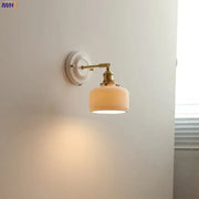 Vintage brass and ribbed glass led wall light with off-white shade providing warm bedroom sconce illumination