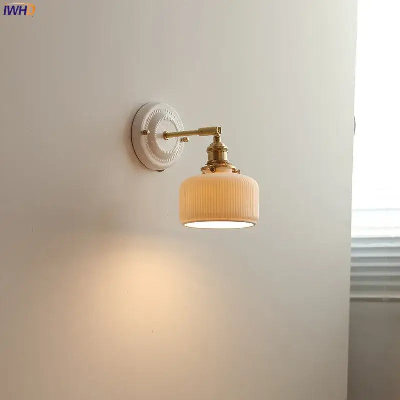 Vintage brass and ribbed glass led wall light with off-white shade providing warm bedroom sconce illumination