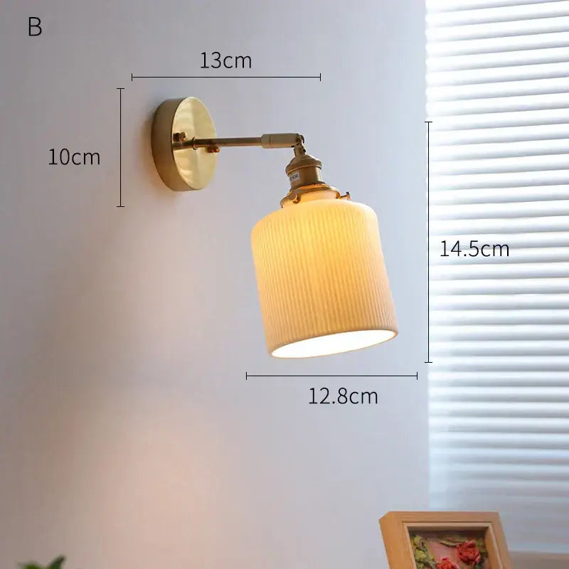 Vintage brass led wall light with ribbed off-white fabric shade designed as a bedroom sconce