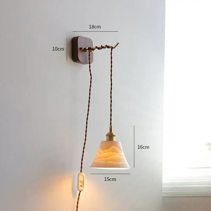 A warm-toned vintage brass and ribbed glass led wall sconce with ceramic pendant lamp and twisted brown cord decorbites led wall