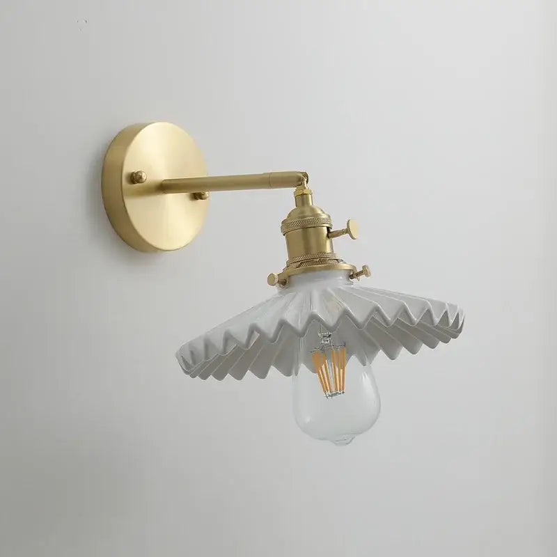 Vintage brass led wall lamp with scalloped white ceramic shade and clear bulb for bedroom lighting
