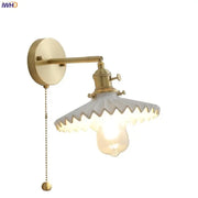 Vintage brass and scalloped glass led wall lamp with exposed bulb designed as a decorative bedroom wall lamp