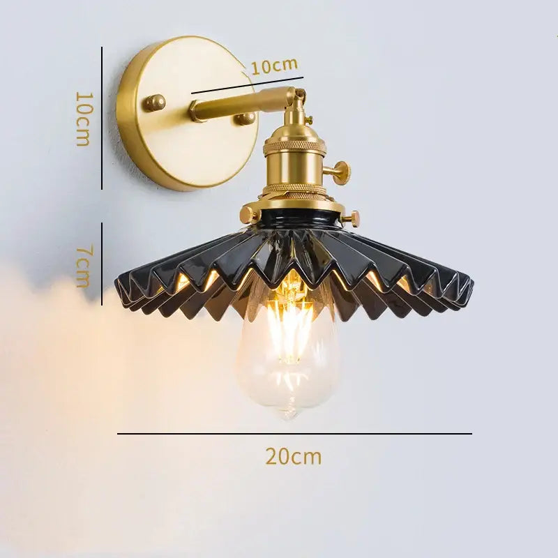 Vintage brass led wall lamp with scalloped black glass shade and ornate metal base for bedroom lighting