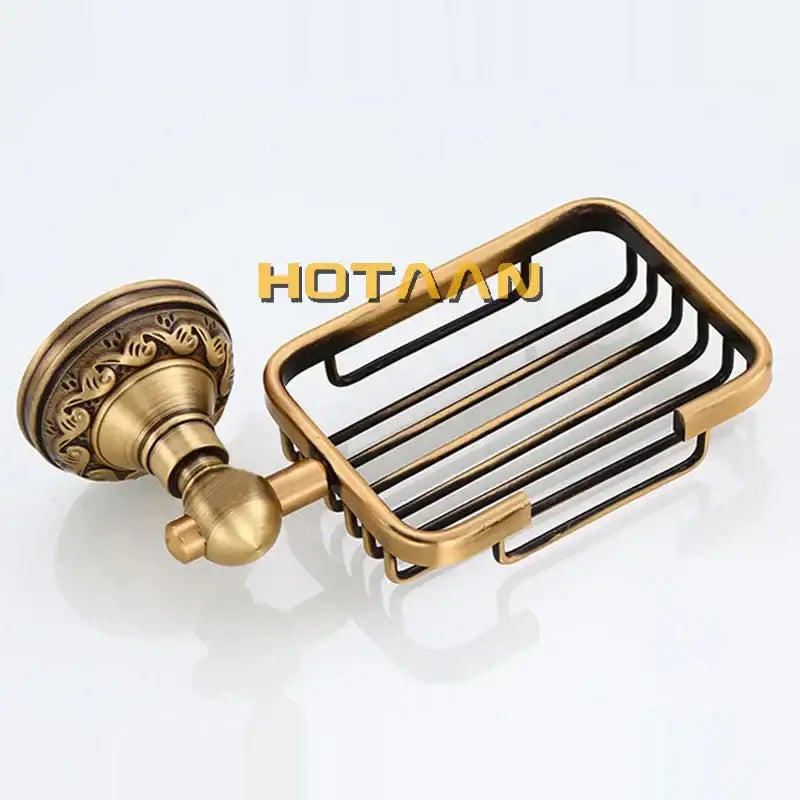 Antique brass-finished metal soap dish with ornate wall-mounted bracket and wire grid design for brass bathroom accessories set