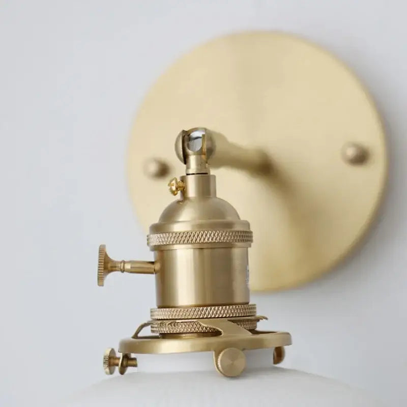 Brass-finished vintage ceramic knob wall light with ribbed glass sconce and circular mounting plate for bedroom use