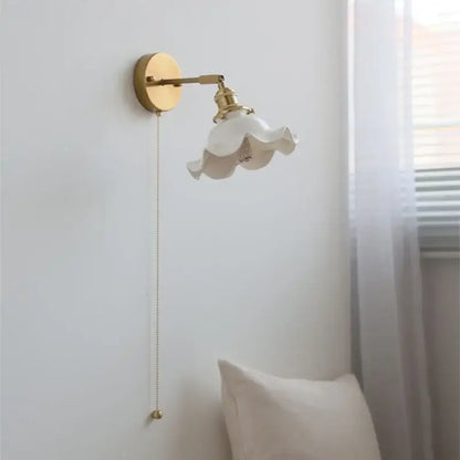 A delicate white ceramic led wall light with ruffled flower-like shade and vintage brass hardware for bedroom decorbites ceramic led wall