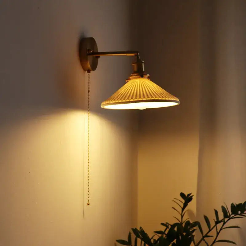 Warm-toned vintage brass ceramic led wall sconce with ribbed cream glass shade and adjustable arm for bedroom decorbites ceramic led