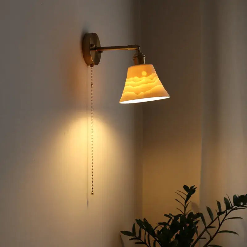 Warm-toned ceramic led wall sconce with sunrise design mounted on vintage brass fixture for bedroom decorbites ceramic led