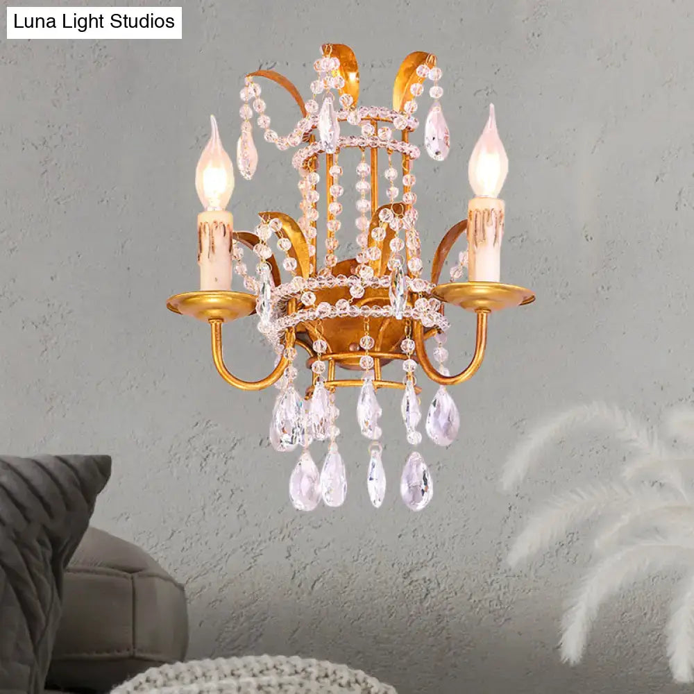 Gold-toned vintage brass wall lamp chandelier sconce with clear crystal teardrop pendants and direct wired bulbs