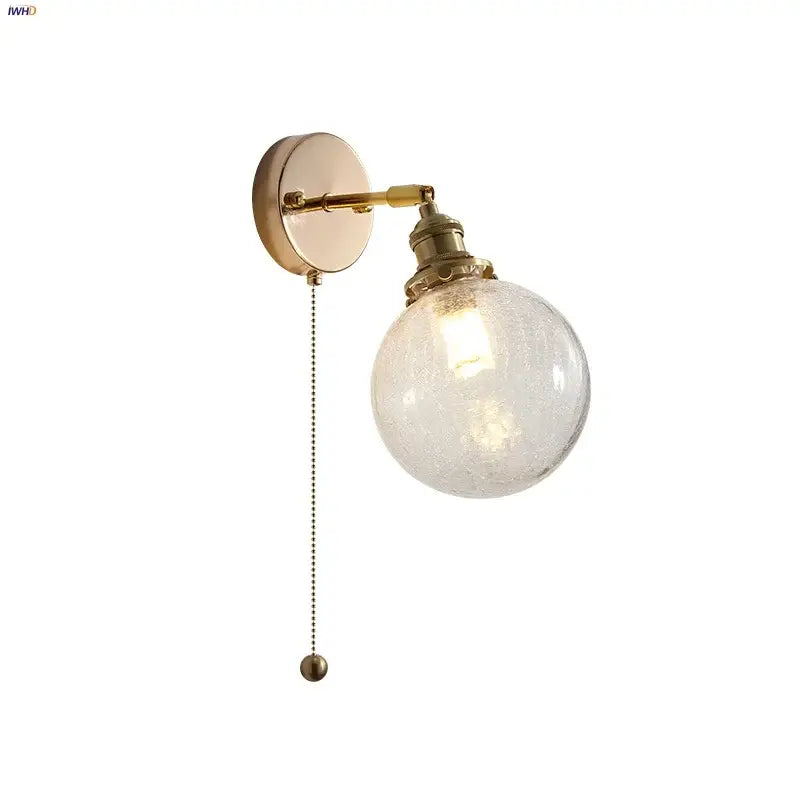 Vintage brass wall lamp with clear glass globe and pull chain switch designed for bathroom use