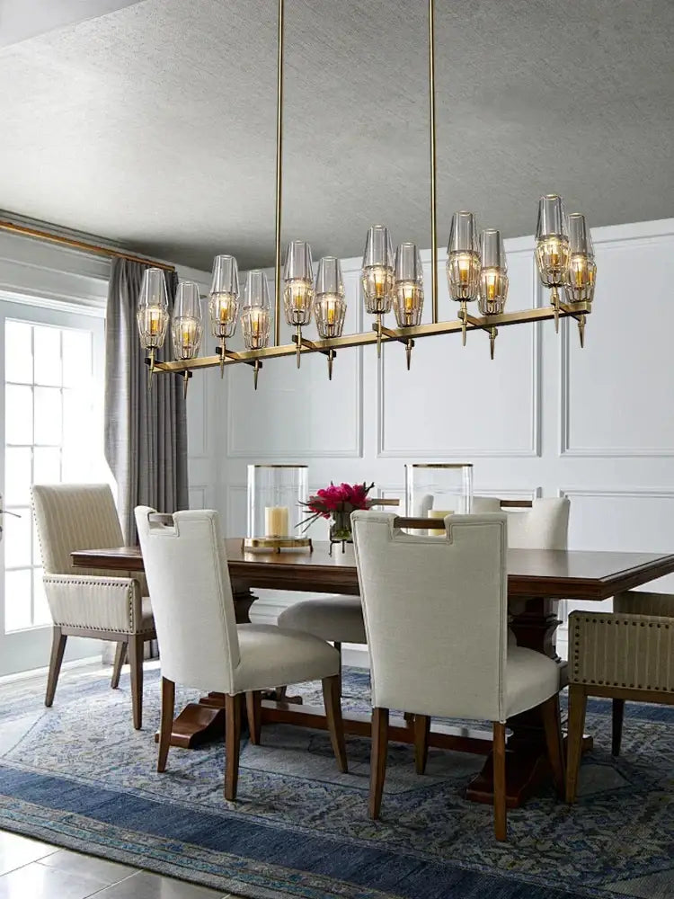 A modern decorbites brass crystal chandelier with clear glass shades and warm bulbs for dining room lighting
