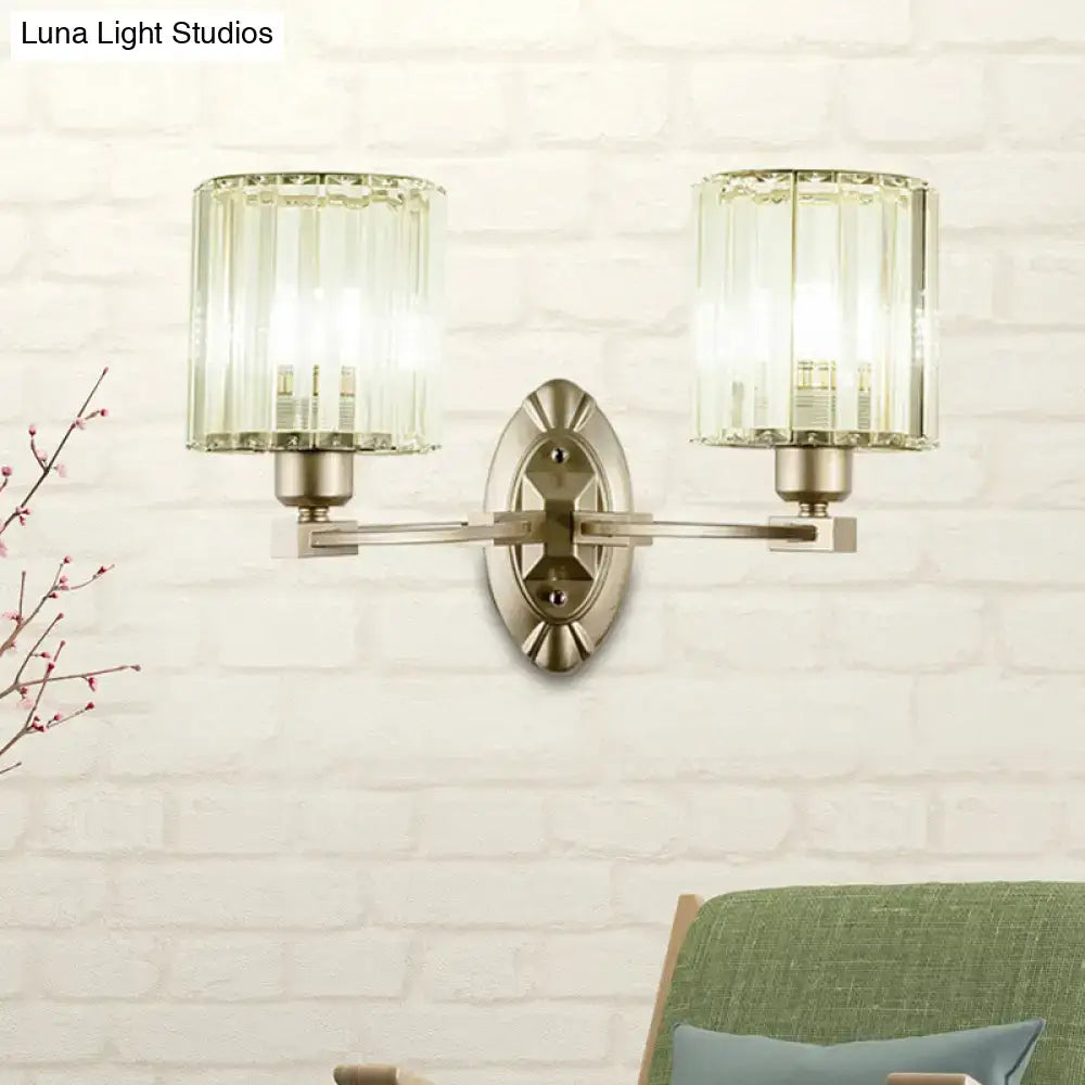 Vintage brass wall light fixture with two cylindrical crystal shades for elegant living room lighting