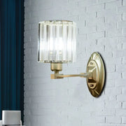 Vintage brass crystal wall light fixture with brass arm and cylindrical prismatic glass shade for living room use