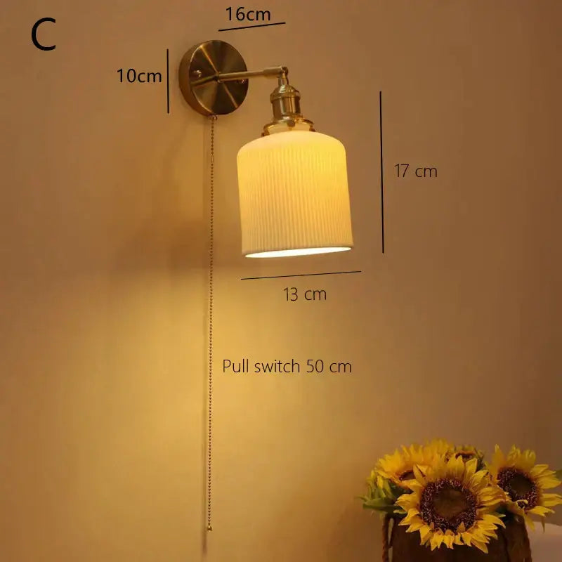 Brass-finished decorbites ceramic sconce lamp with ribbed off-white glass shade and pull chain for bedroom reading light