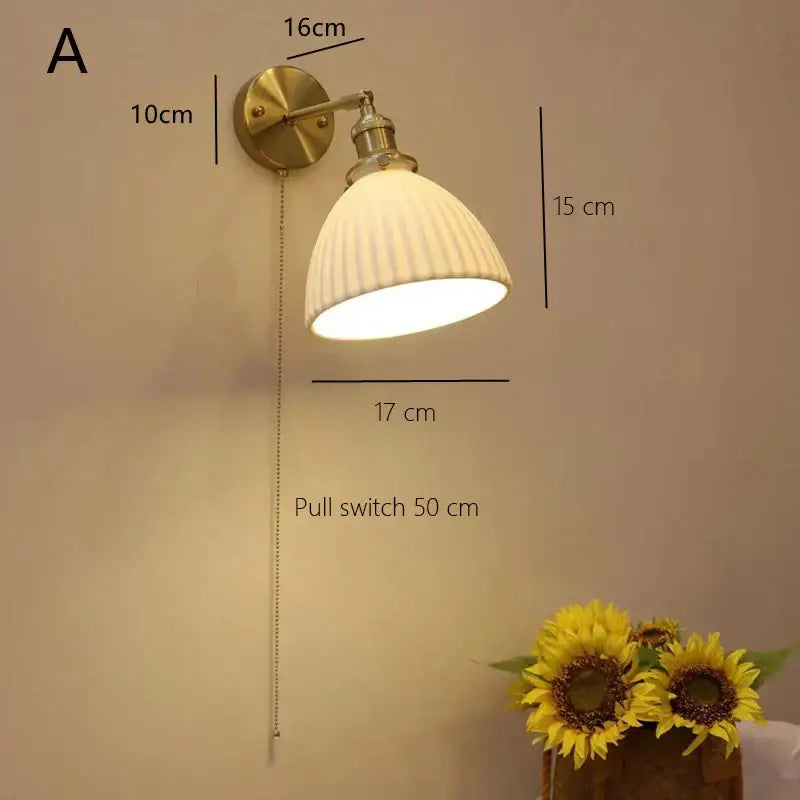 Brass-finished wall-mounted decorbites ceramic sconce lamp with ribbed off-white shade and adjustable pull-chain switch for reading