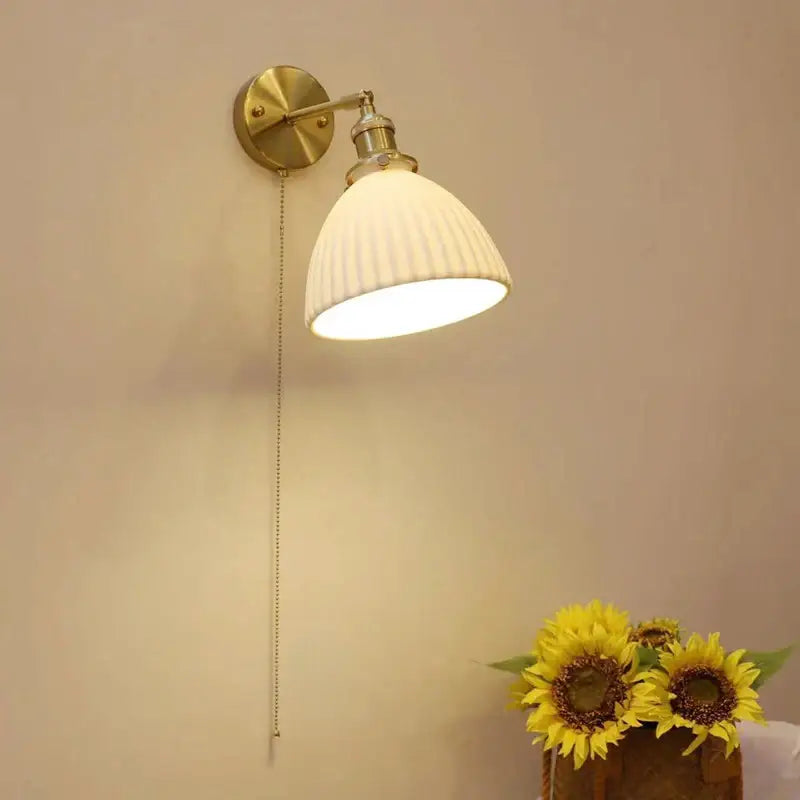Vintage brass decorbites ceramic sconce lamp with ribbed off-white ceramic shade and adjustable arm for bedroom reading light