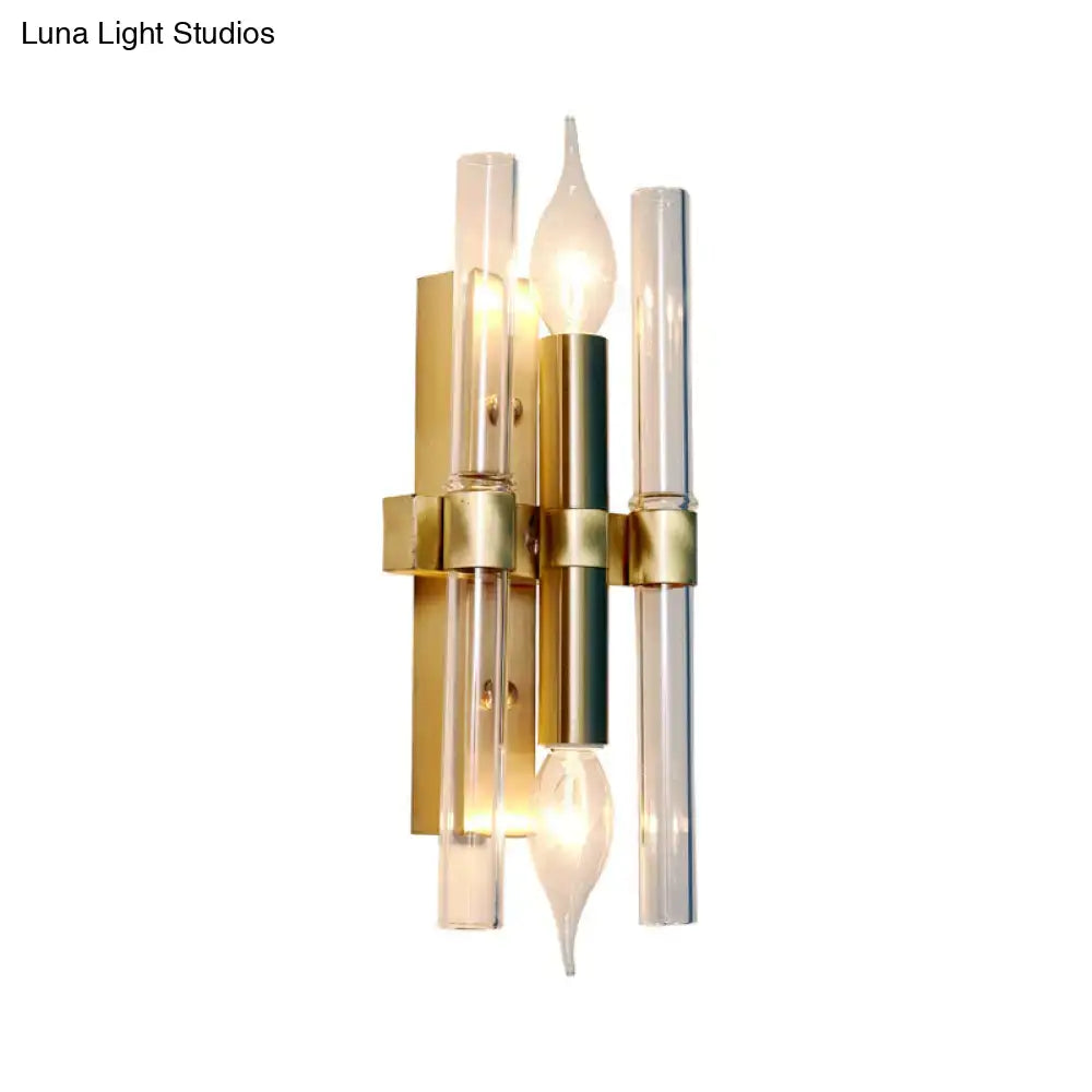 Gold-toned vintage brass finish candle wall sconce with clear glass tubes and candle-shaped bulbs for living room decor