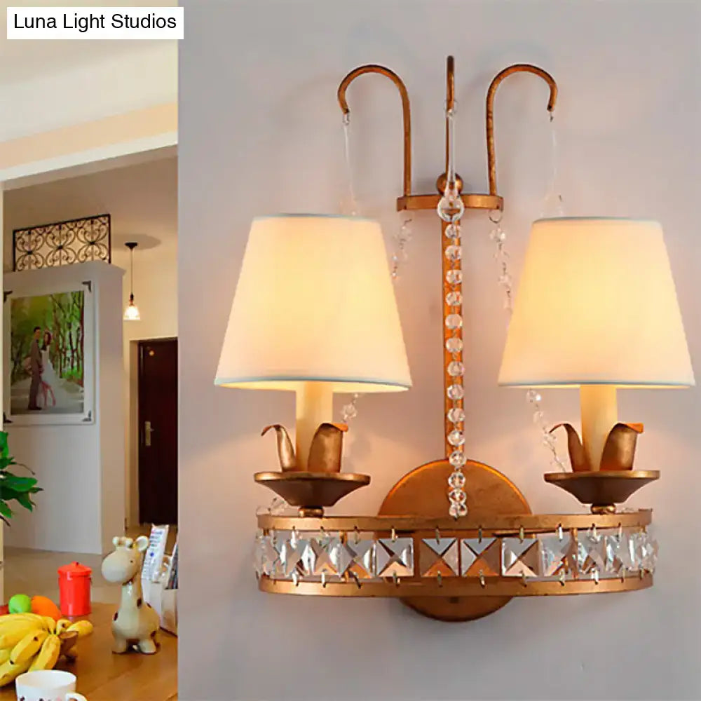 Vintage brass finish wall lamp with gold-toned sconce, cream lampshades, crystal accents, and decorative bird motifs