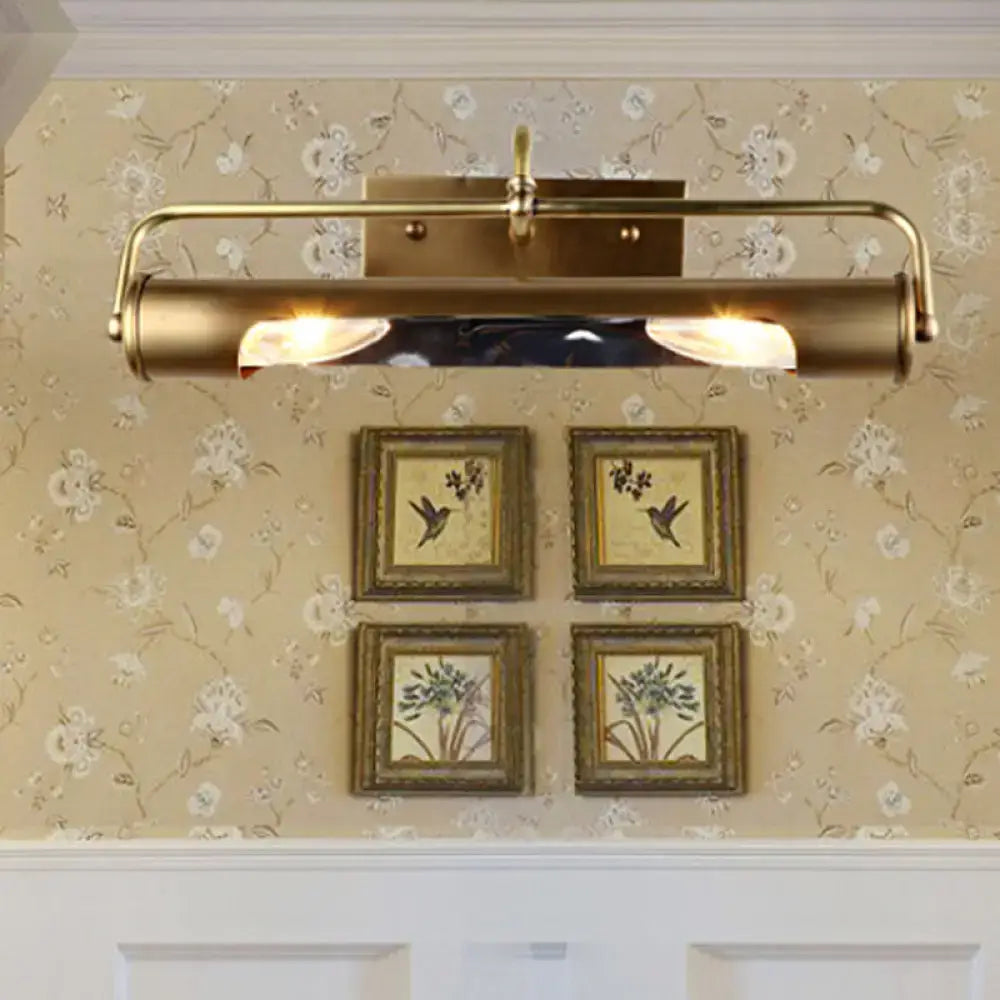 Vintage brass finish wall-mounted vanity lamp with two illuminated bulbs and sleek cylindrical design for bathroom