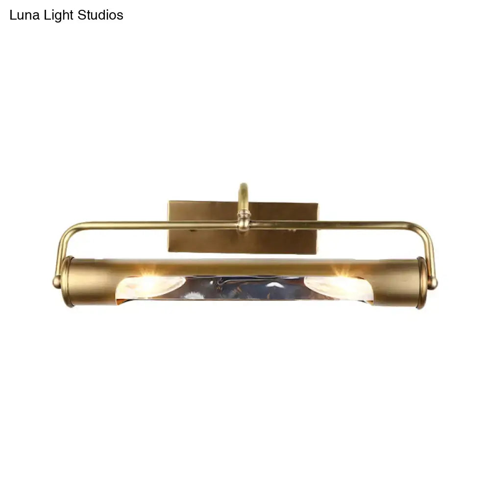 Vintage brass finish cylindrical vanity lamp with sleek elongated design and clear glass panels for bathroom use