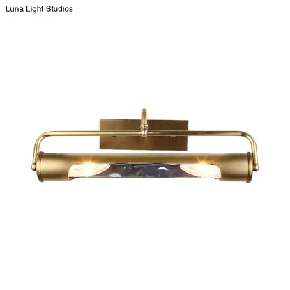 Vintage brass finish cylindrical vanity lamp with sleek elongated design and clear glass panels for bathroom use