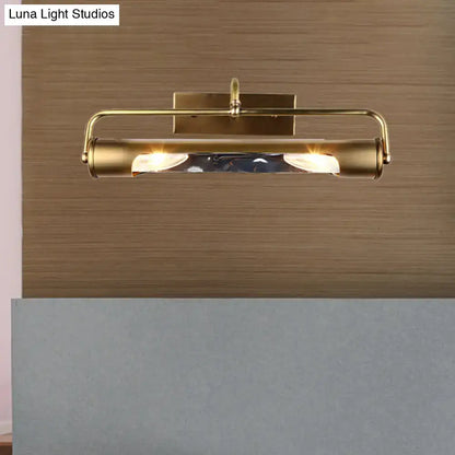 Vintage brass finish cylindrical vanity lamp with wall-mounted spotlight design and warm-toned bulbs for bathroom use
