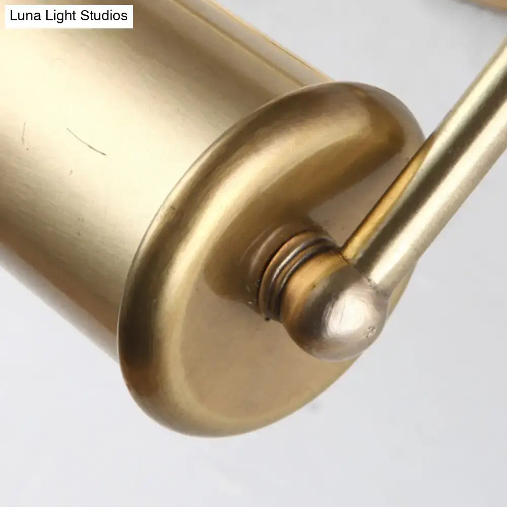 Brass finish cylindrical wall-mounted toilet paper holder with sleek rounded design for vintage vanity lamp setup