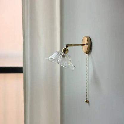 Vintage brass wall light with a clear fluted glass bedside sconce and elegant pull-chain switch for bedroom decorbites