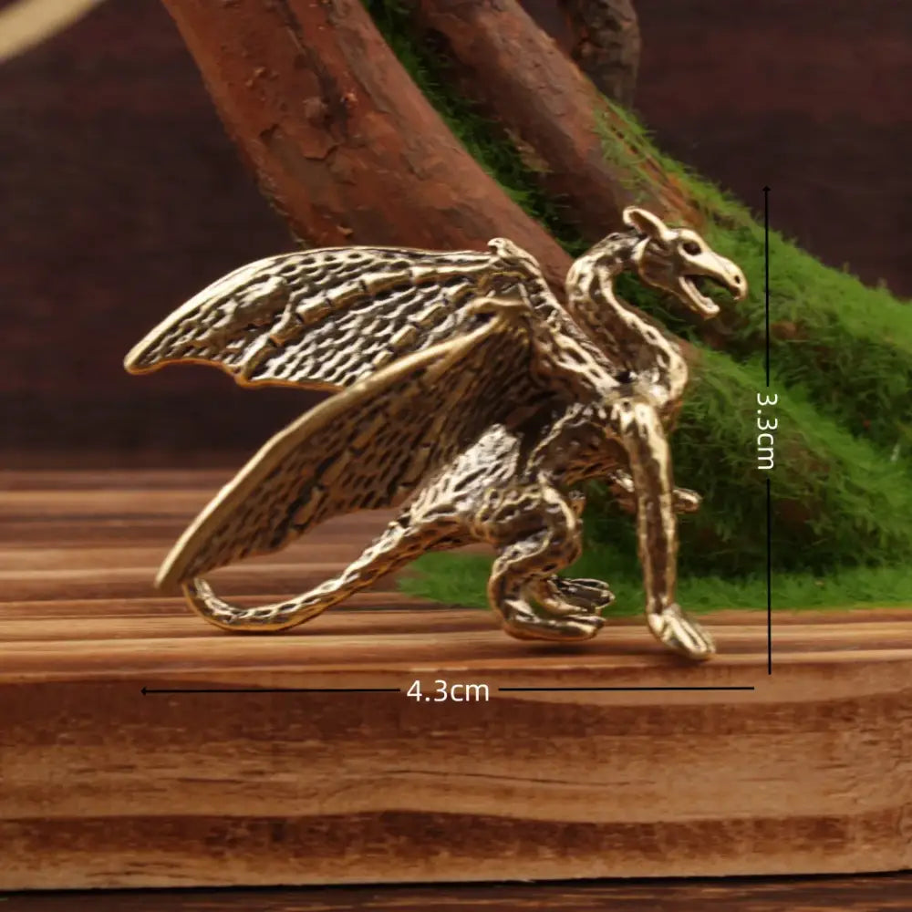 Vintage decorbites brass flying dragon sculpture in gold tone with textured wings and scales on wooden surface decor