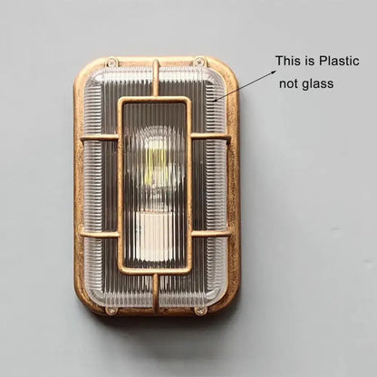 Vintage brass gas station canopy wall light with a ribbed translucent cover and metal frame for outdoor security