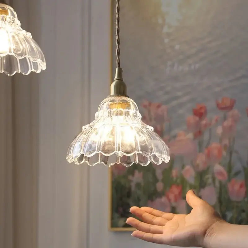 Clear glass led pendant lamp with a fluted petal design and vintage brass metal hardware for kitchen lighting