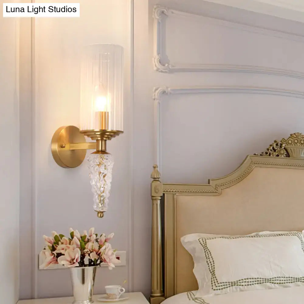 Vintage brass wall mounted lighting fixture with gold-toned glass shade and ornate faceted crystal pendant for bedroom use