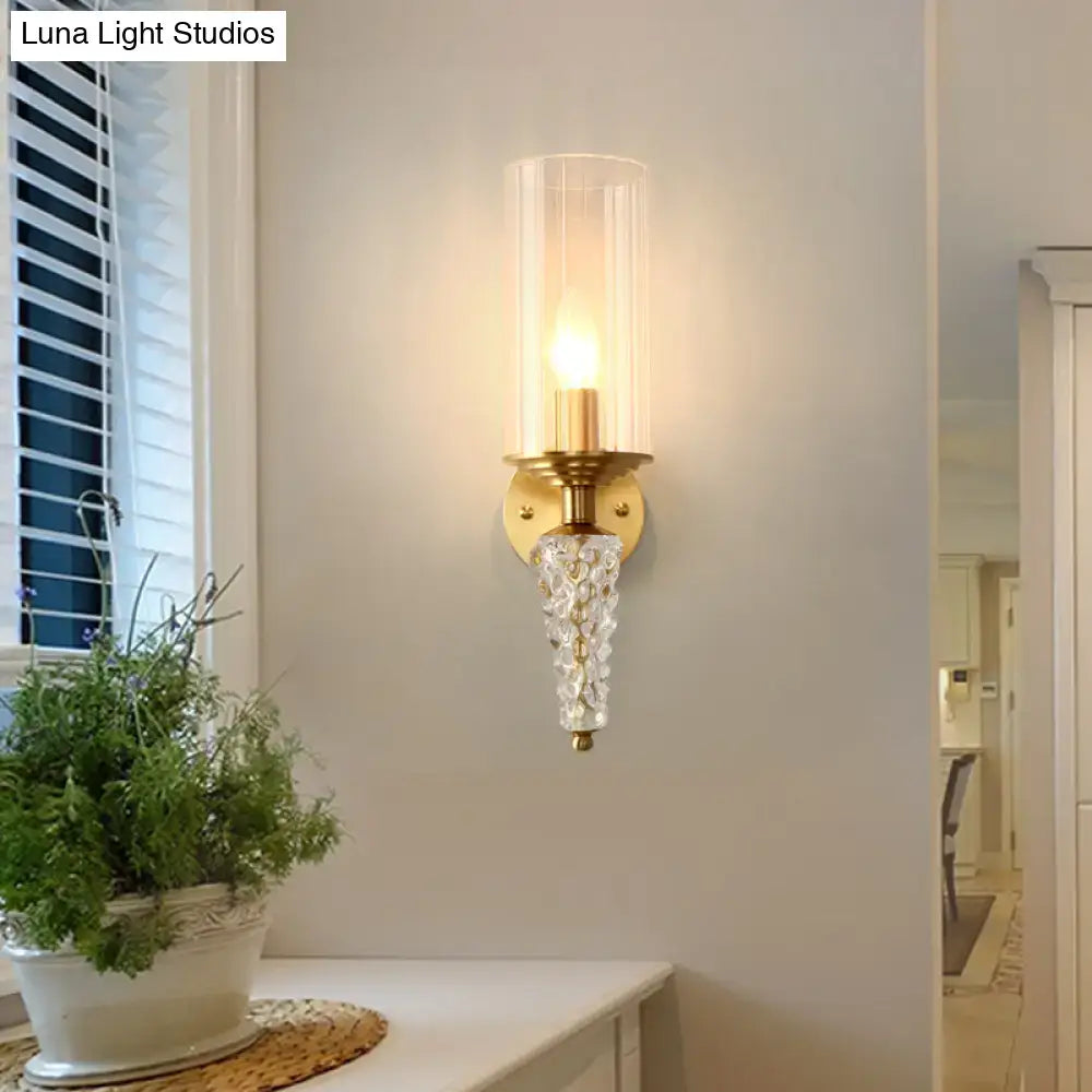 Vintage brass wall mounted lighting fixture with gold-toned glass shade and ornate crystal pendant for bedroom use