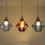Three geometric brass vintage led pendant lights with clear amber and teal stained glass panels for dining room decorbites
