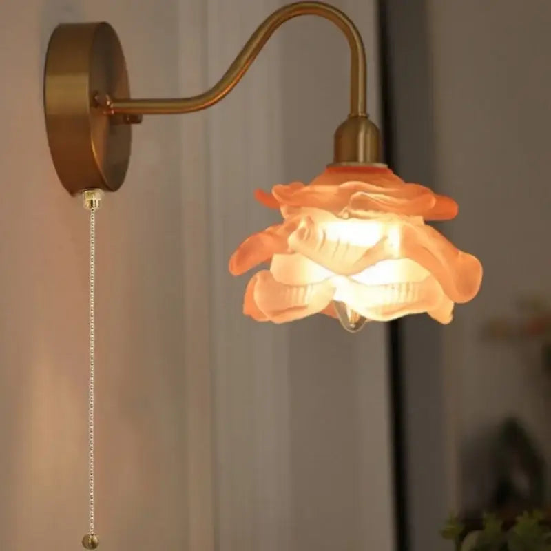 A warm-toned rose-shaped glass lampshade brass led wall sconce with decorbites brass led pull chain arm for bathroom vanity