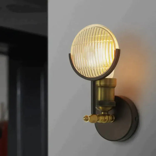 Vintage brass ribbed glass led wall lamp sconce with circular lens emitting warm light for bedroom lighting