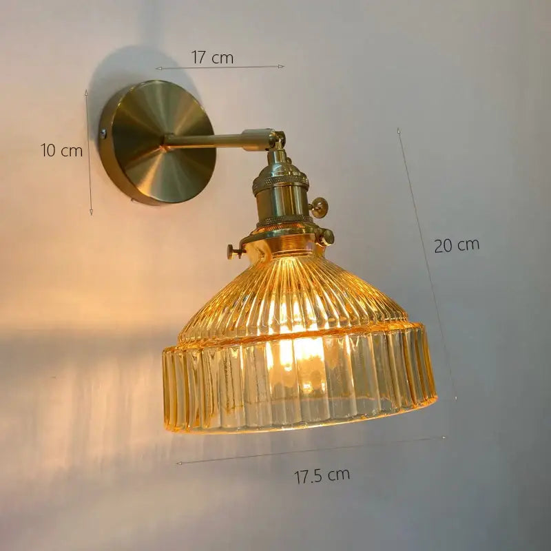 Vintage brass wall sconce with amber ribbed glass shade providing warm light for bedroom wall lamp use