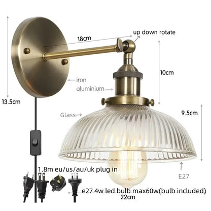 Antique brass wall sconce with ribbed glass shade and adjustable arm featuring a pull chain switch for bedroom light